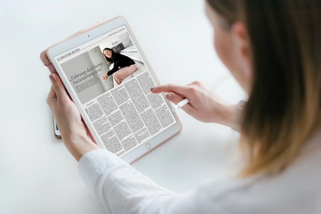 Person liest Magazin-Artikel auf einem Ipad