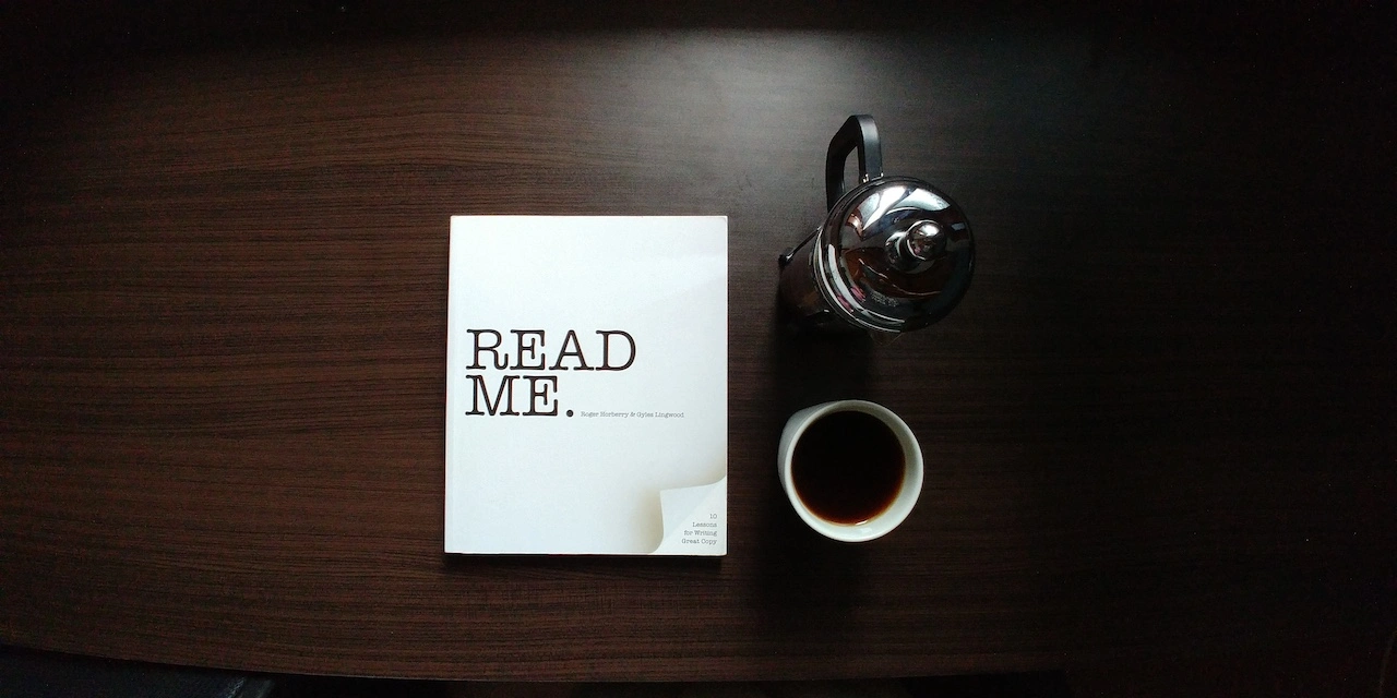 Tisch mit Kaffetasse und Blog auf dem "Read me" steht
